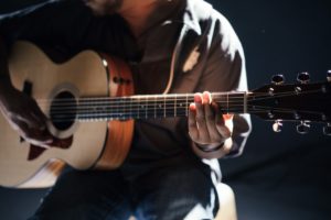 Lone acoustic guitarist and possible introvert. One must schmooze a little to get more paid gigs.