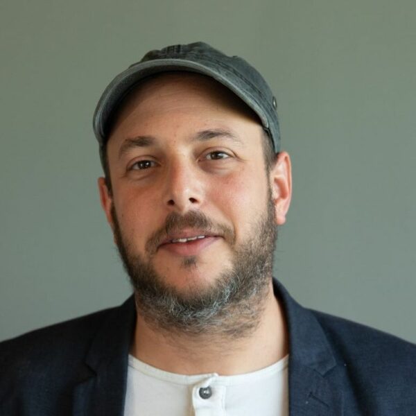 Ori Winokur of Artlist.io in denim cap, white buttton tee and blue sports jacket, headshot