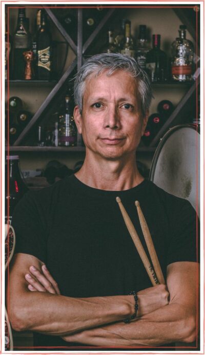 Robonzo, Host of Unstarving Musician, wearing black tee, holding drumsticks