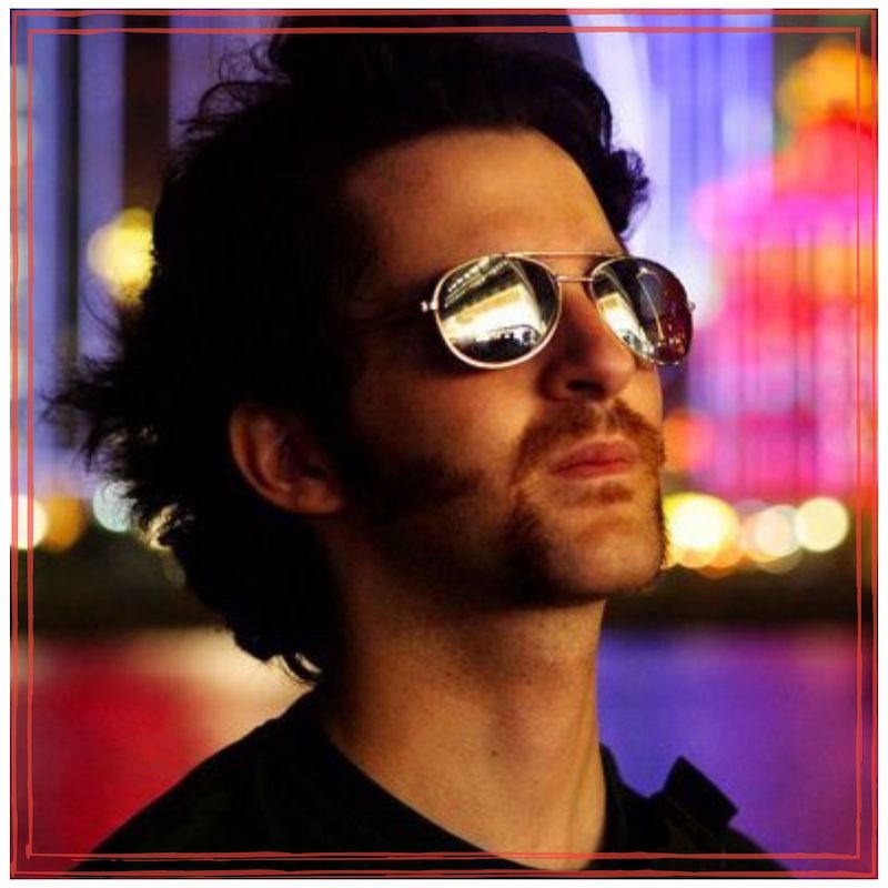 Zack O’Malley Greenburg wearing aviators, somewhere in Asia at night, looking hip