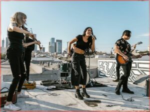 Band performing on outdoor rooftop under blue skies