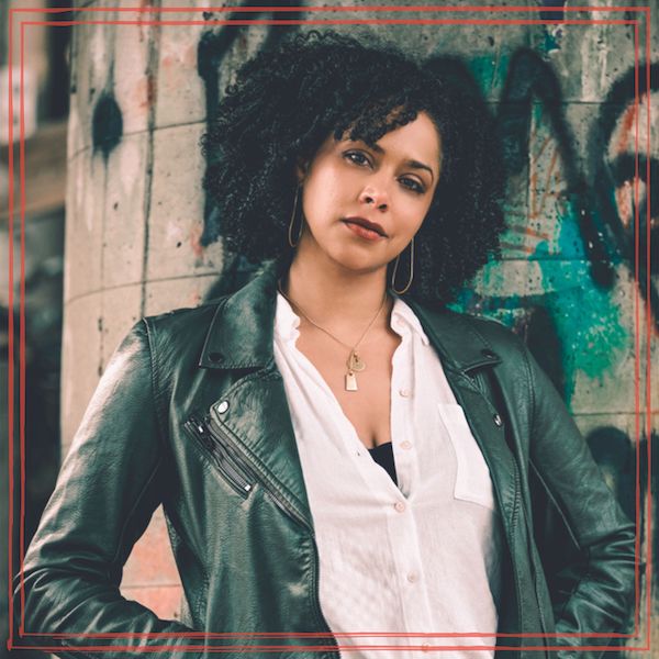 Tracee Perrin in dark jacket and white shirt against graffiti backdrop