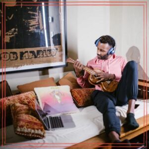 Man sitting on a wooden sofa playing ukulele | Photo by RDNE Stock project: https://www.pexels.com/photo/a-man-sitting-on-a-wooden-sofa-while-playing-ukulele-6517306/