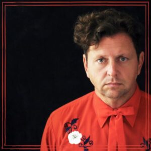 abe partridge wearing red shirt on black backround