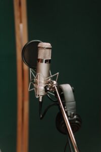 A silver microphone near the black headphones | Image buy cottonbro studio https://www.pexels.com/photo/a-silver-microphone-near-the-black-headphones-7086288/