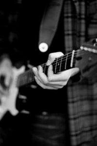 Monochrome shot of person playing guitar | Image by Jack Murphy on Pexels | https://www.pexels.com/photo/monochrome-shot-of-a-person-playing-guitar-11372430/